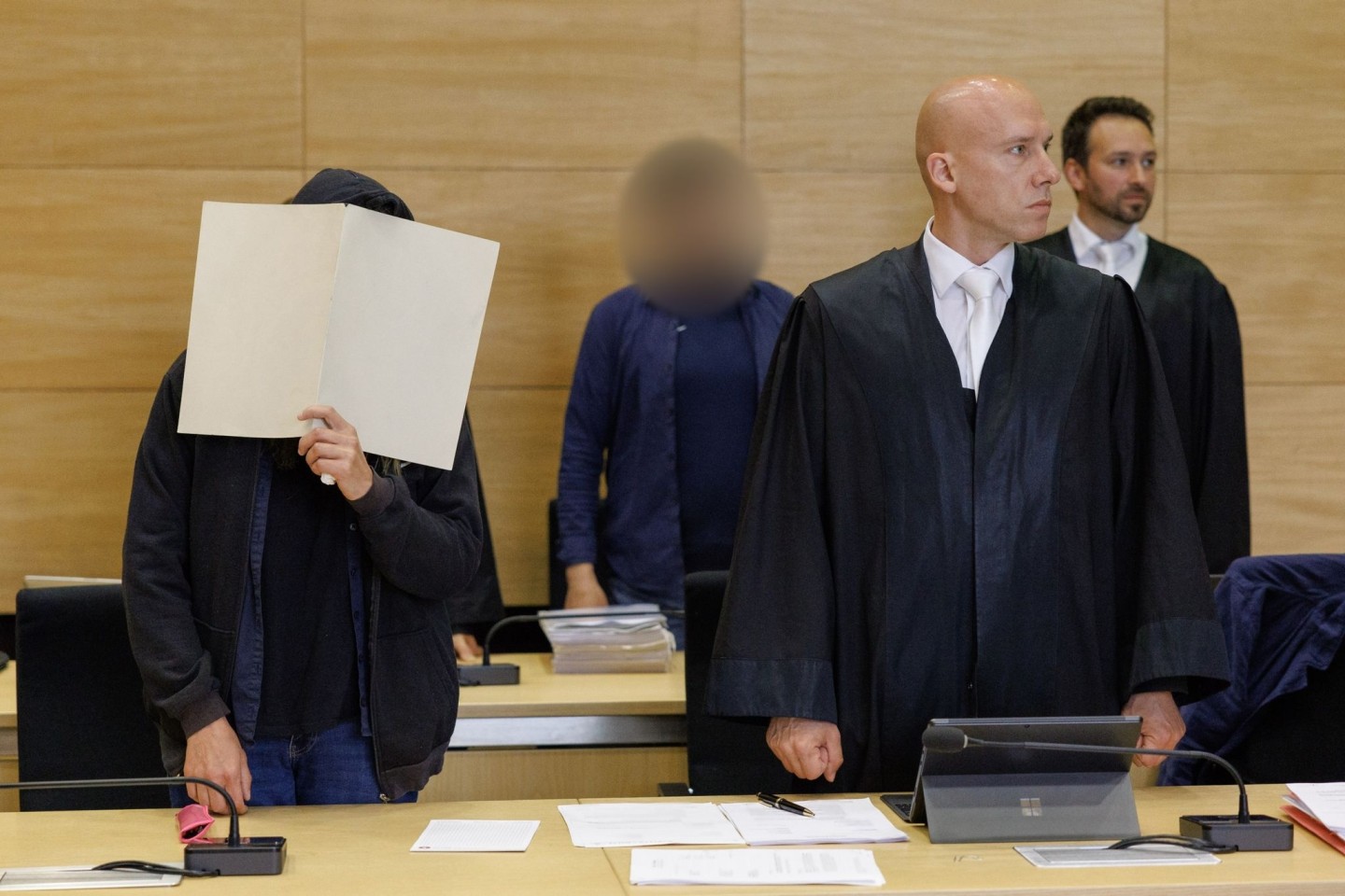 Die Angeklagten im Landgericht Bielefeld neben ihren Rechtsanwälten.