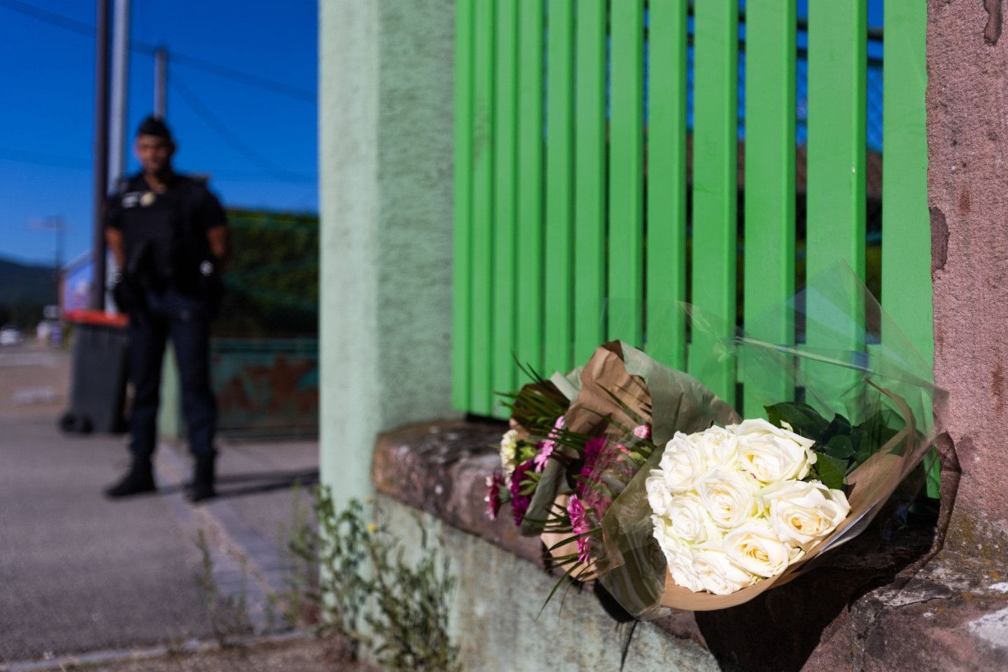 Blumen am Eingang des Grundstücks, auf dem am Mittwoch bei einem Feuer elf Menschen ums Leben kamen.