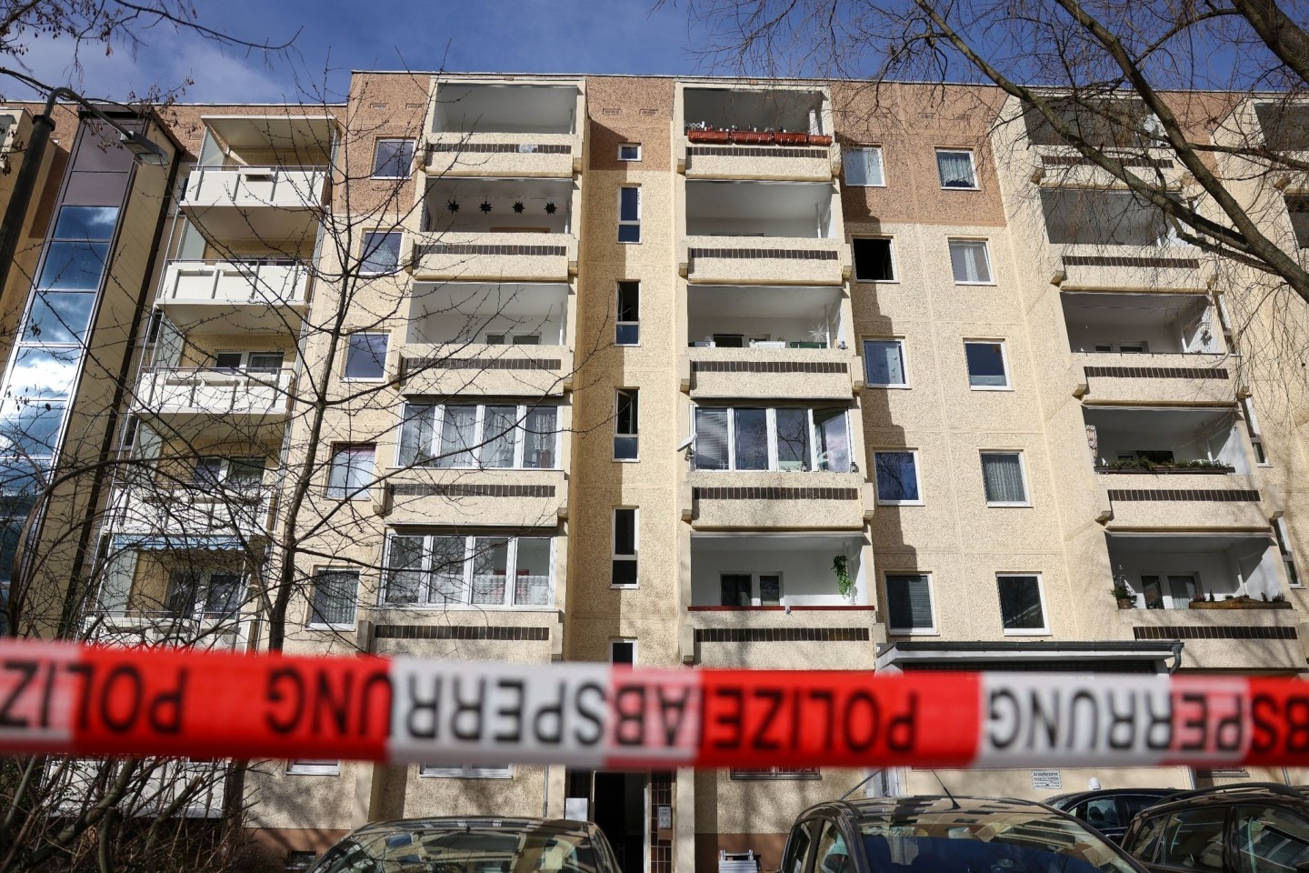 Absperrband der Polizei hängt nach dem Brand im Leipziger Stadtteil Paunsdorf vor dem Plattenbau.