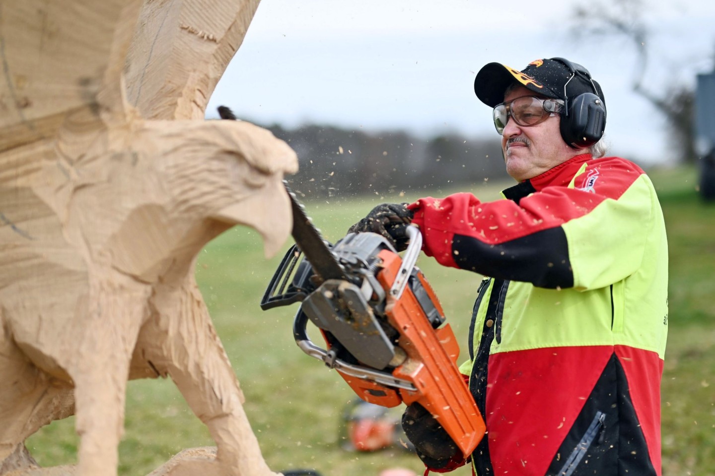 Der Kettensägen-Holzschnittkünstler Dieter Binder arbeitet an einer Skulptur in Form eines Adlers.