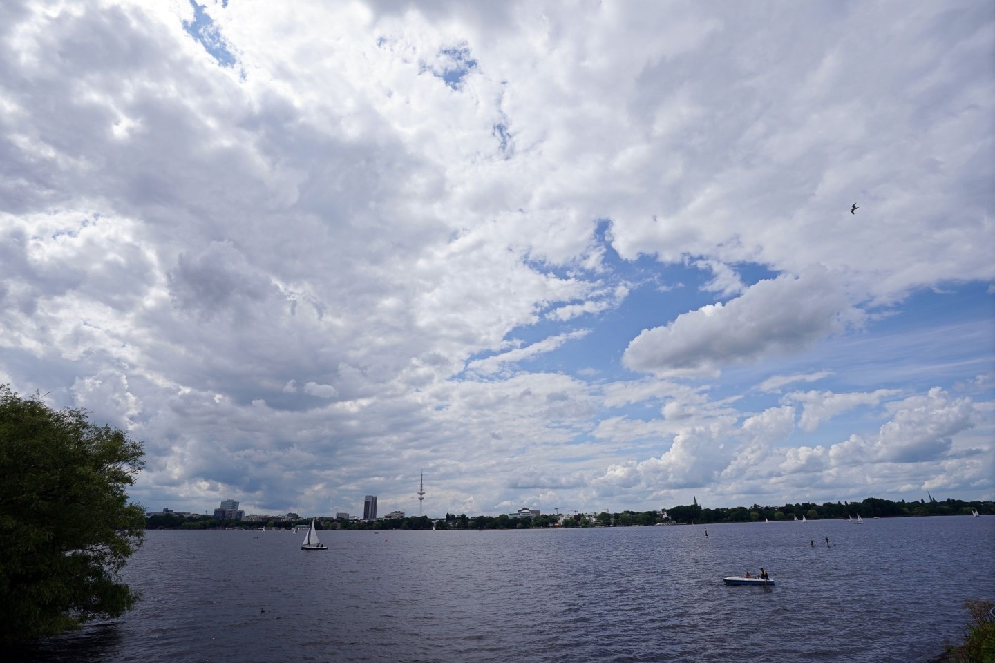 Dichte Wolken ziehen über die Segelboote und Tretboote auf der Außenalster hinweg.