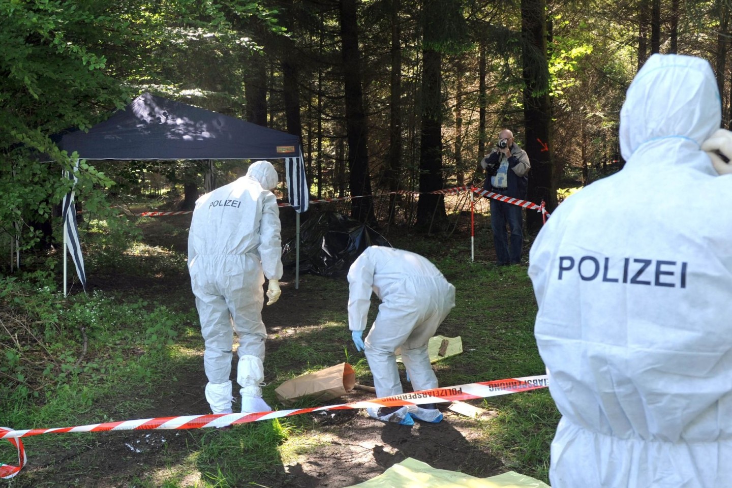 Kriminalbeamte untersuchen im Juni 2010 bei Heidenheim-Nietheim den Waldboden.