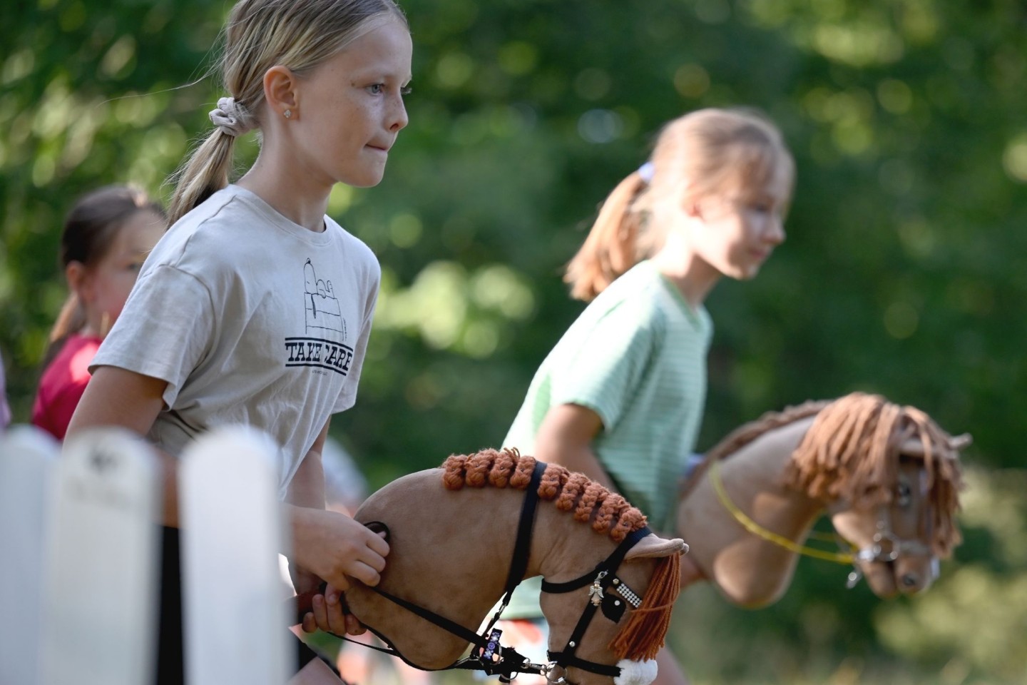 Zwei Mädchen beim Hobby Horsing-Kurs im Berliner Volkspark Wuhlheide.