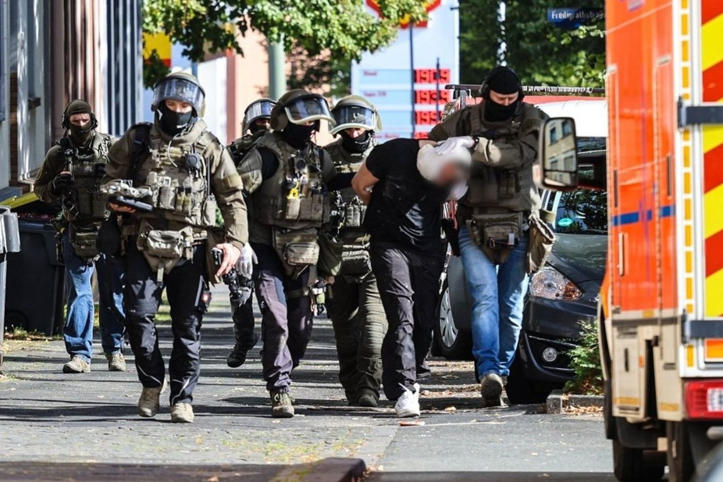 Spezialkräfte der Polizei führen den Verdächtigen ab.