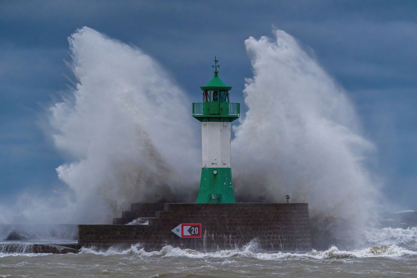 Wellen der Ostsee peitschen bei einem schweren Sturmtief an den Leuchtturm auf der Ostmole. Wegen des Sturmtiefs sind an der Ostseeküste Straßen und Uferbereiche vom Hochwasser überschwem...