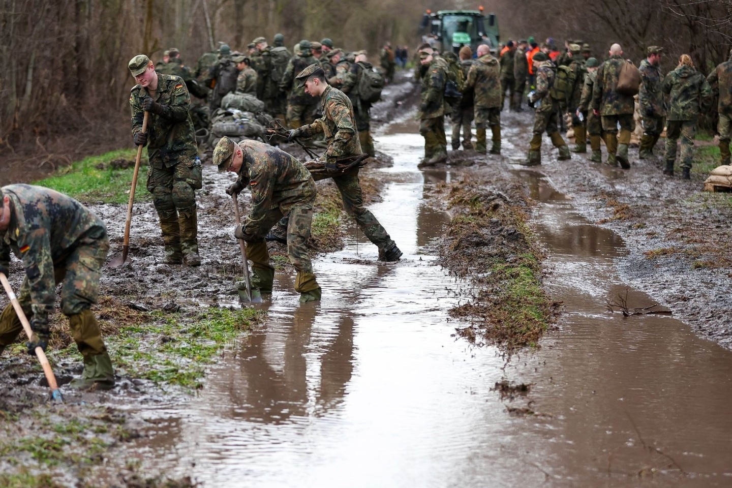 Soldatinnen und Soldaten der Bundeswehr sichern einen Deich an der Helme mit Sandsäcken.