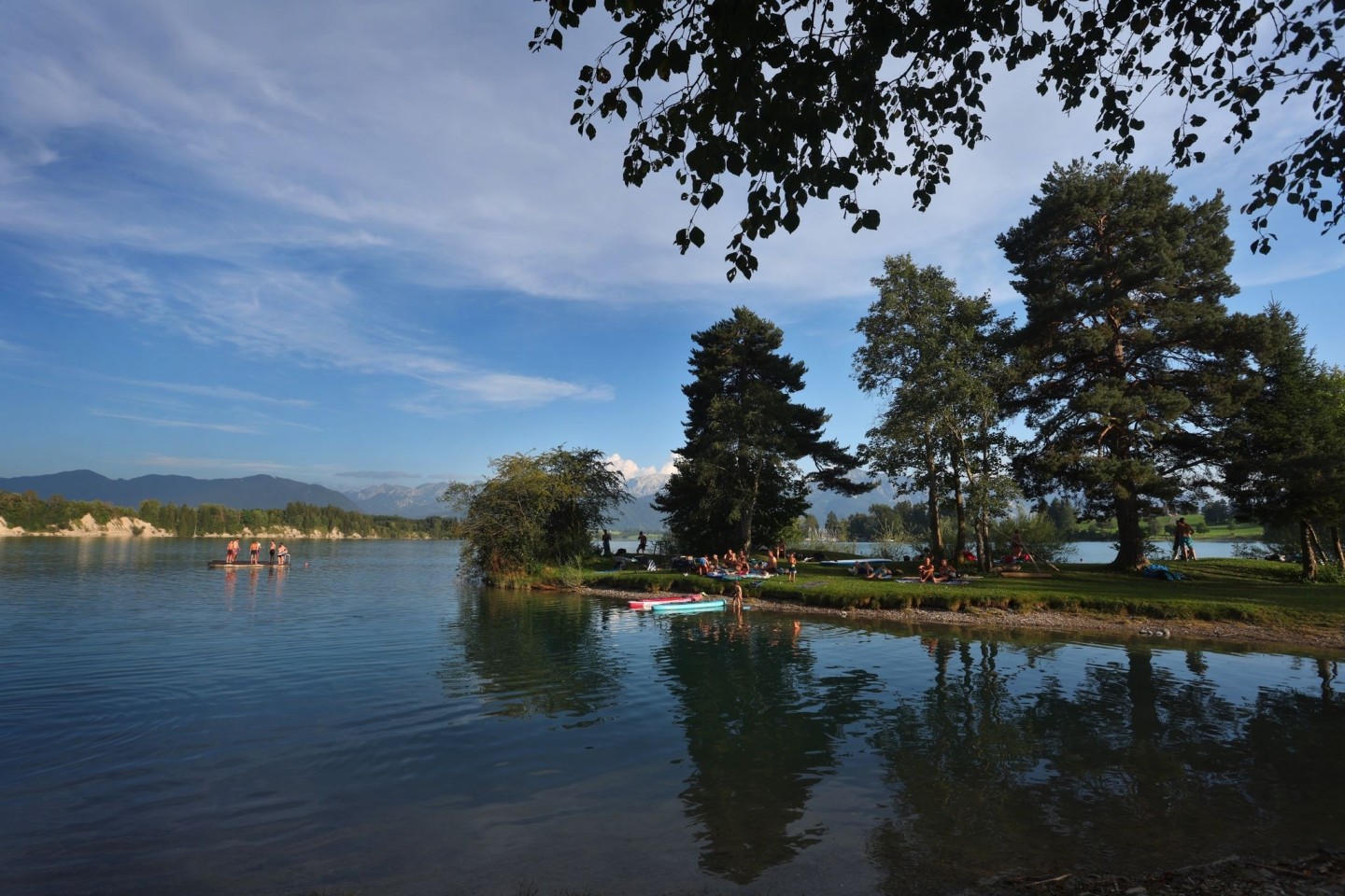 Badegäste suchen Abkühlung in einer Bucht am Forggensee in Bayern.