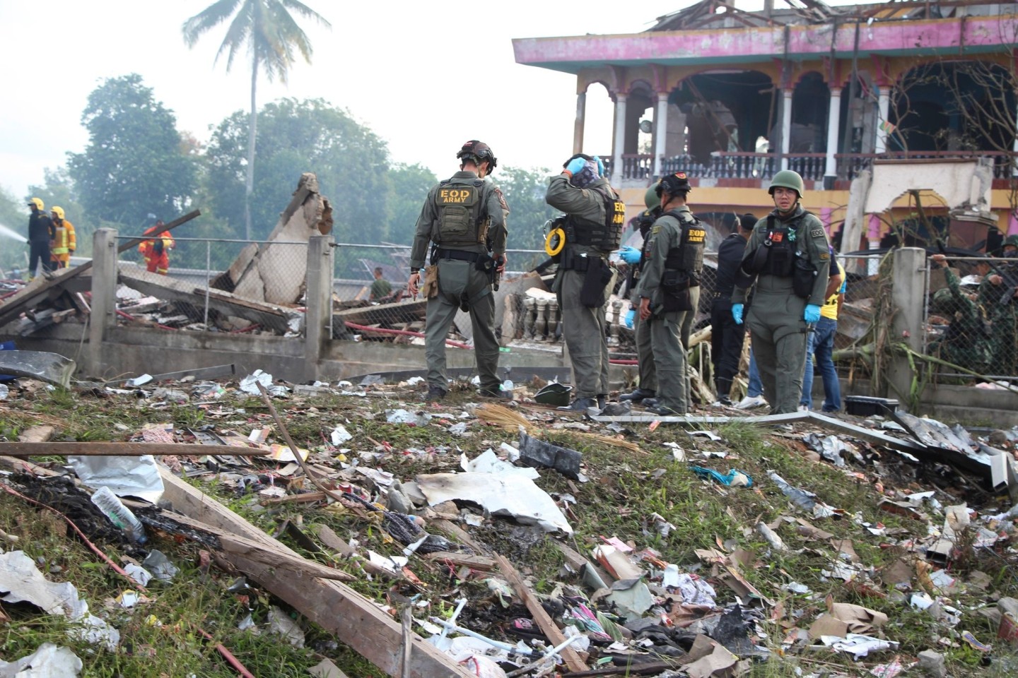 Einsatzkräfte des Kampfmittelräumdienstes untersuchen die Überreste eines durch eine Explosion zerstörten Gebäudes in Thailand.