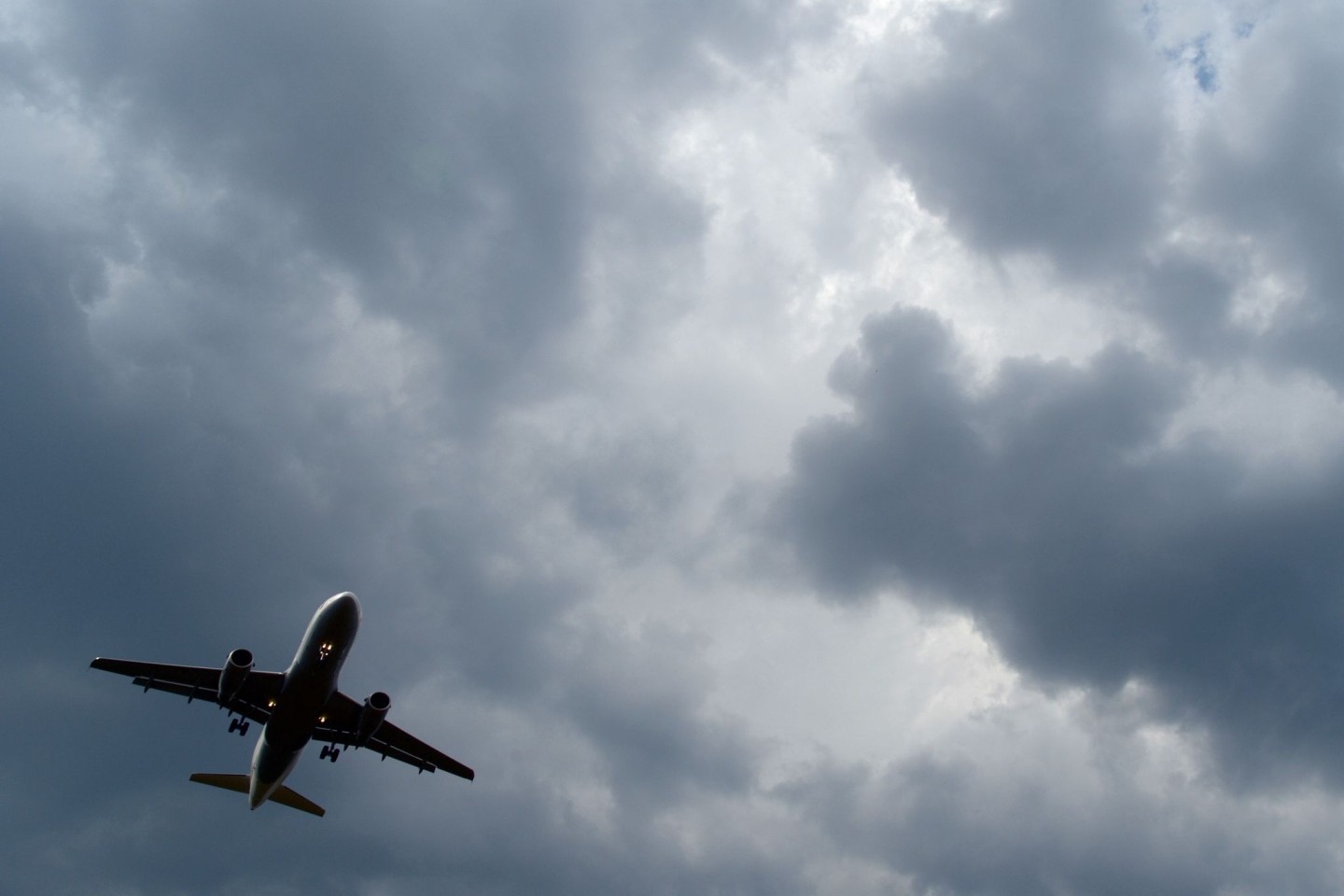 Gewitterwolken türmen sich über einem Flugzeug auf.